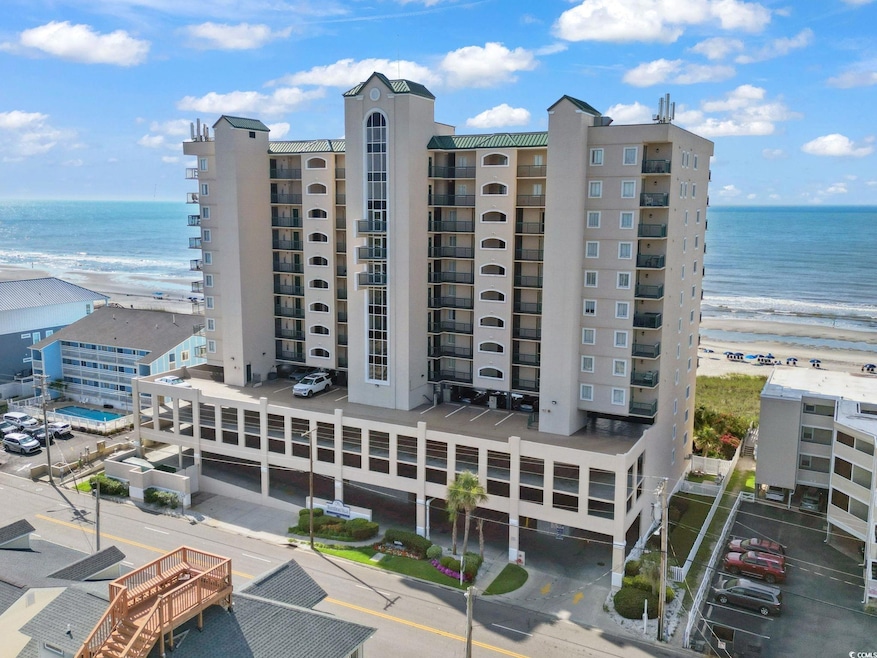 View of apartment building / complex with view of water and beach
