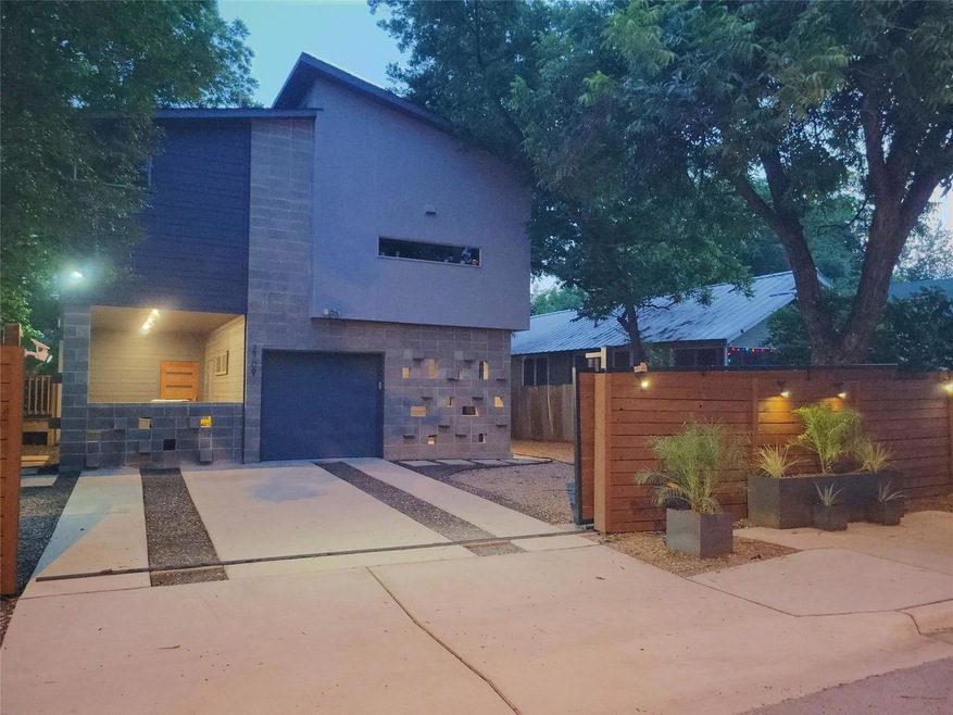 Contemporary home with driveway, fence, stone sid