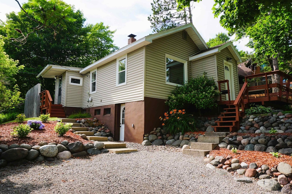 View of property exterior with stairs, a chimney, and a deck