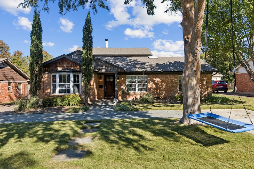 Front elevation featuring extensive stonework and landscaping