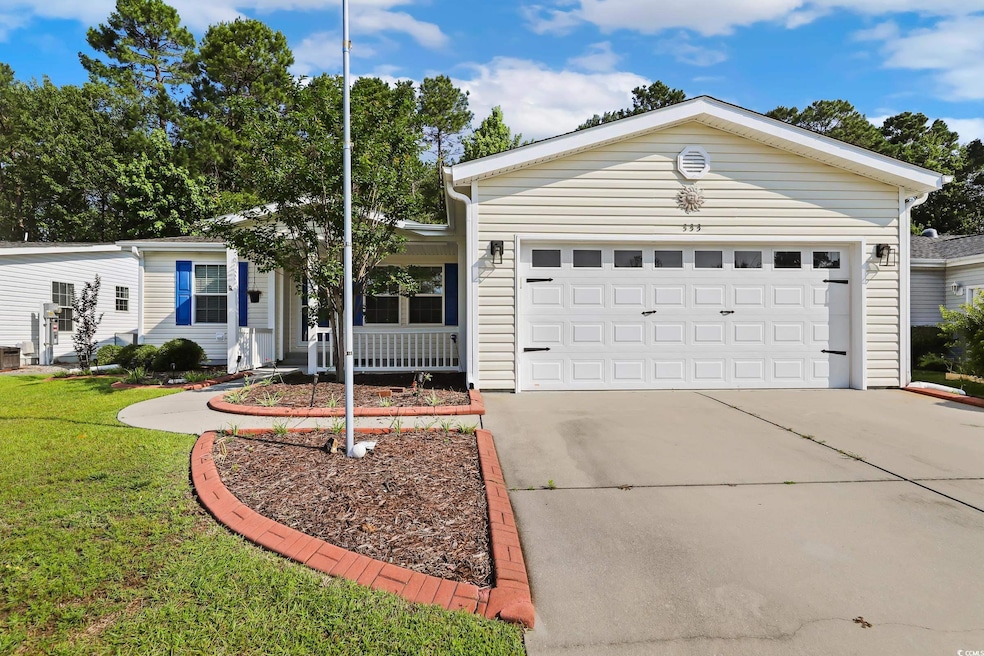 Ranch-style home featuring a front yard, driveway, covered porch, and a garage