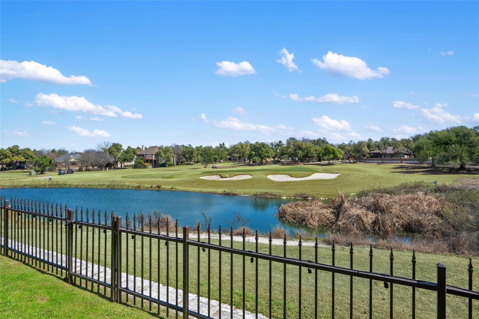 Property view of water with fence and view of gol