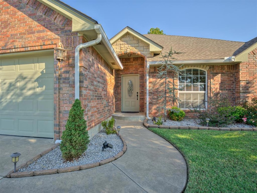 Property entrance with brick siding, an attached garage, a shingled roof, and a lawn