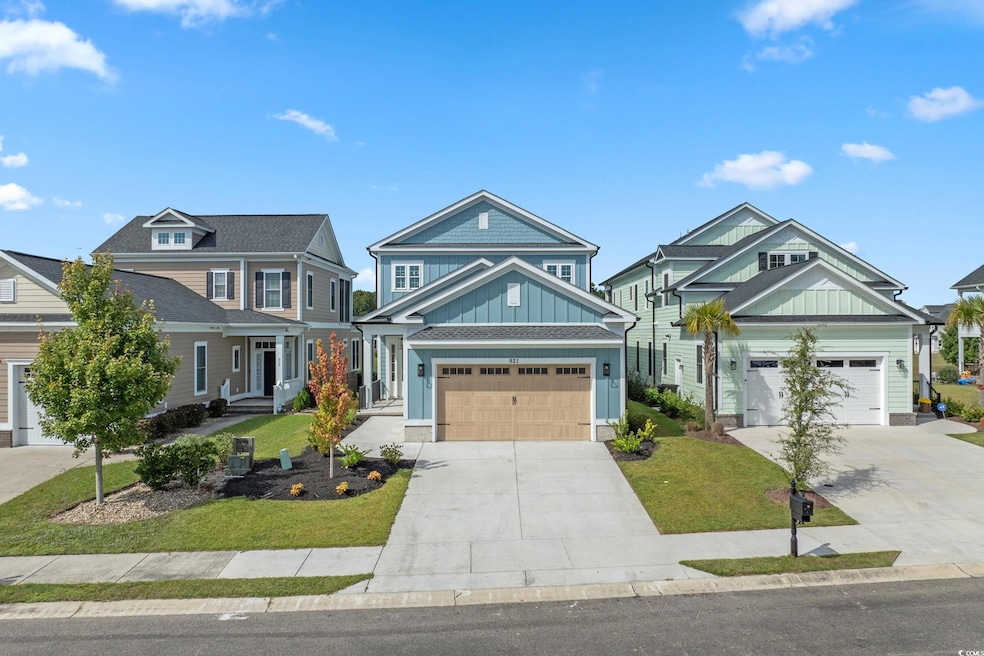 Craftsman-style home featuring board and batten siding, concrete driveway, and a front lawn