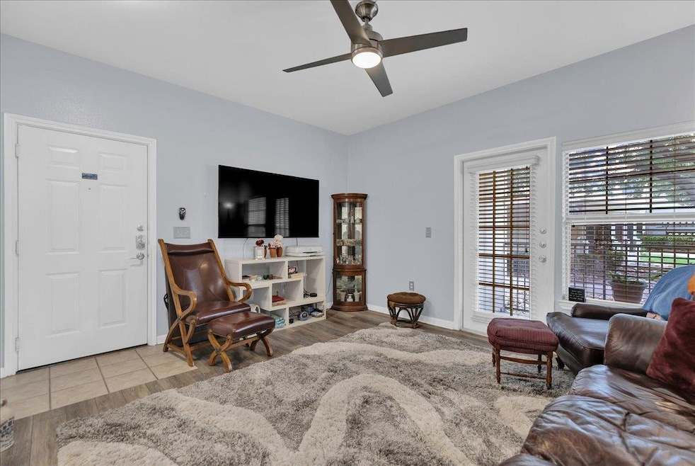 Living room featuring ceiling fan and wood finish