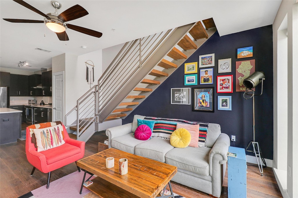 Living room with ceiling fan, visible vents, wood