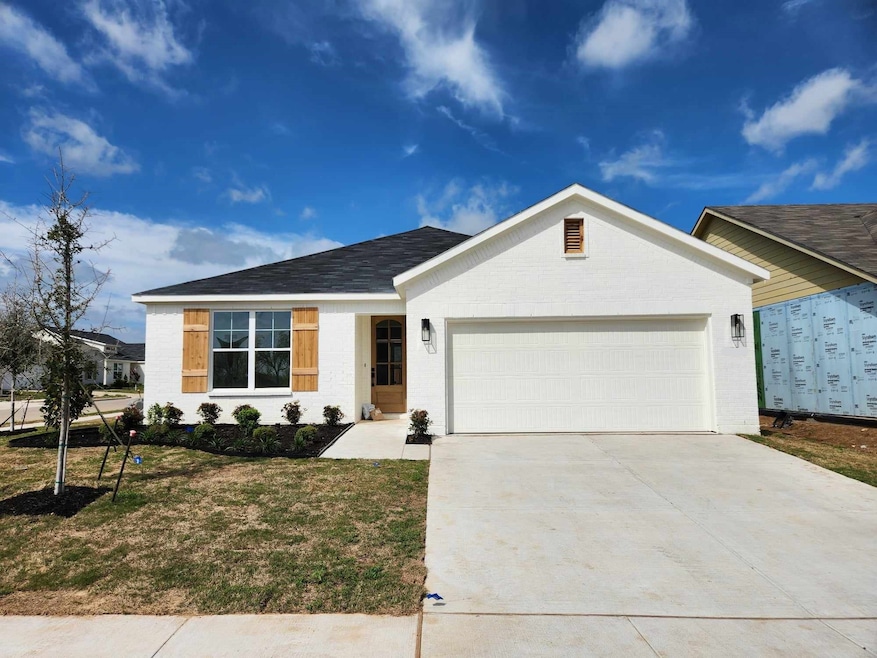 Ranch-style house featuring a front yard and a garage