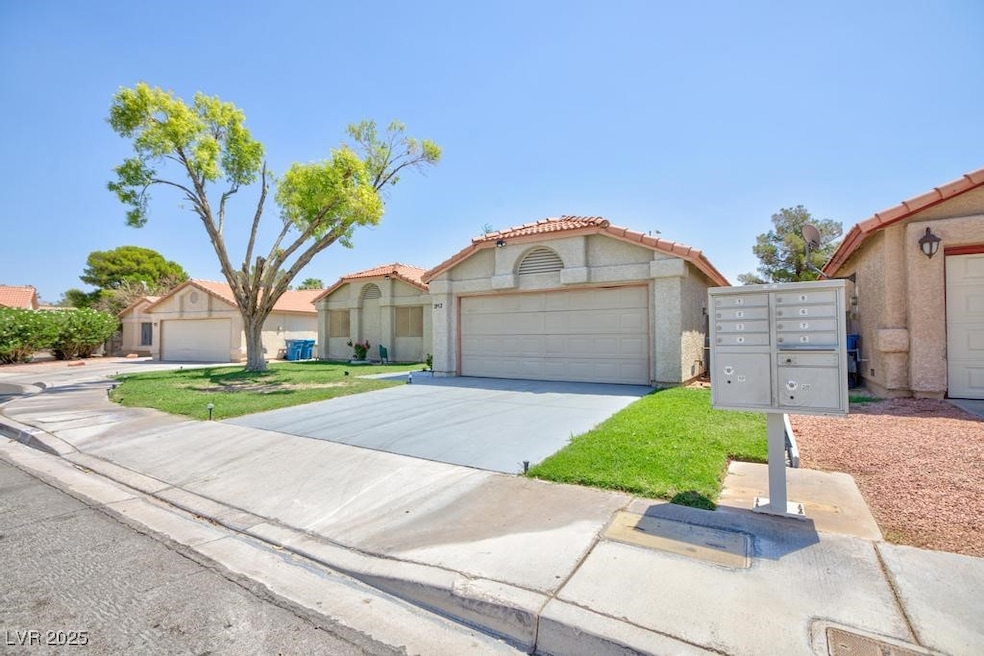Mediterranean / spanish-style house featuring a tiled roof, concrete driveway, an attached garage, and stucco siding