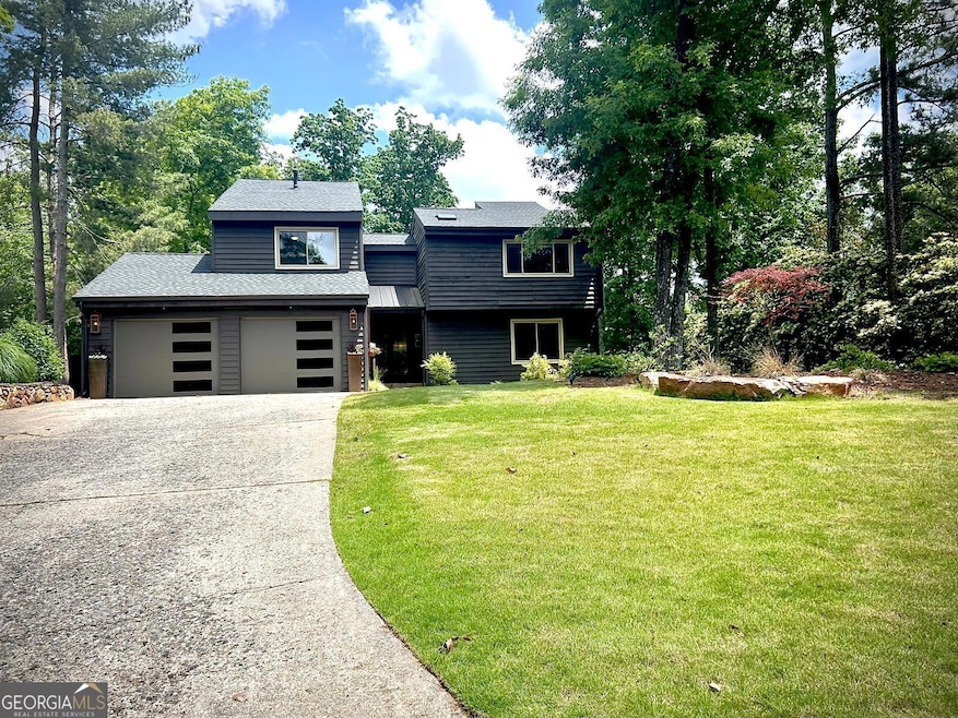 Front of Structure - View of front of house with driveway, a front yard, a shingled roof, and a garage