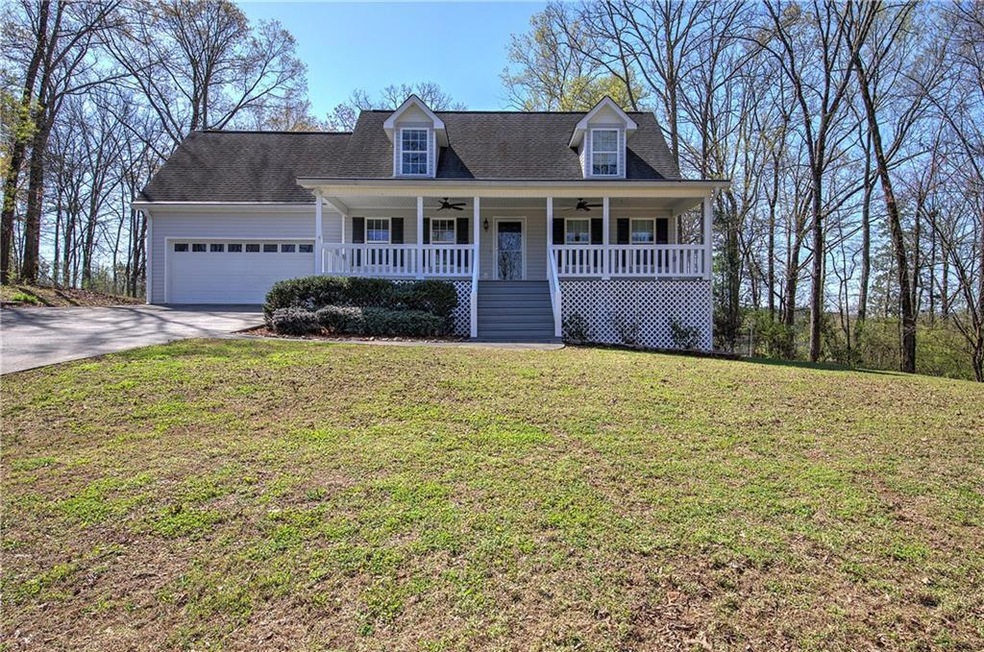 Cape cod home featuring covered porch, a front yar