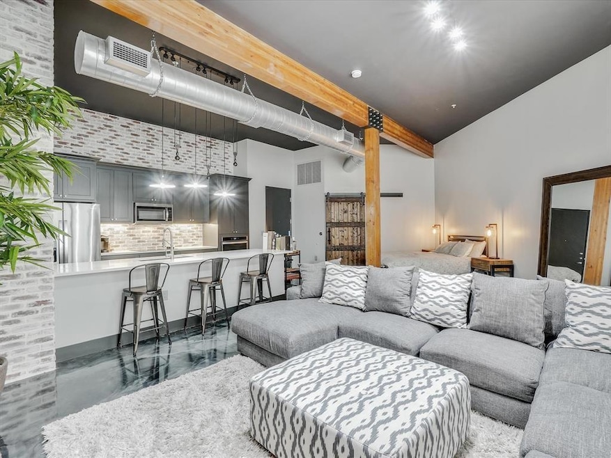 Living room with concrete floors, a towering ceili