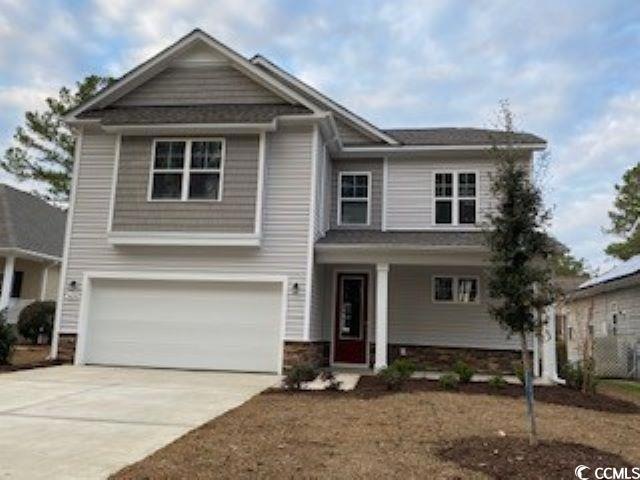 Craftsman inspired home featuring driveway, a garage, and stone siding