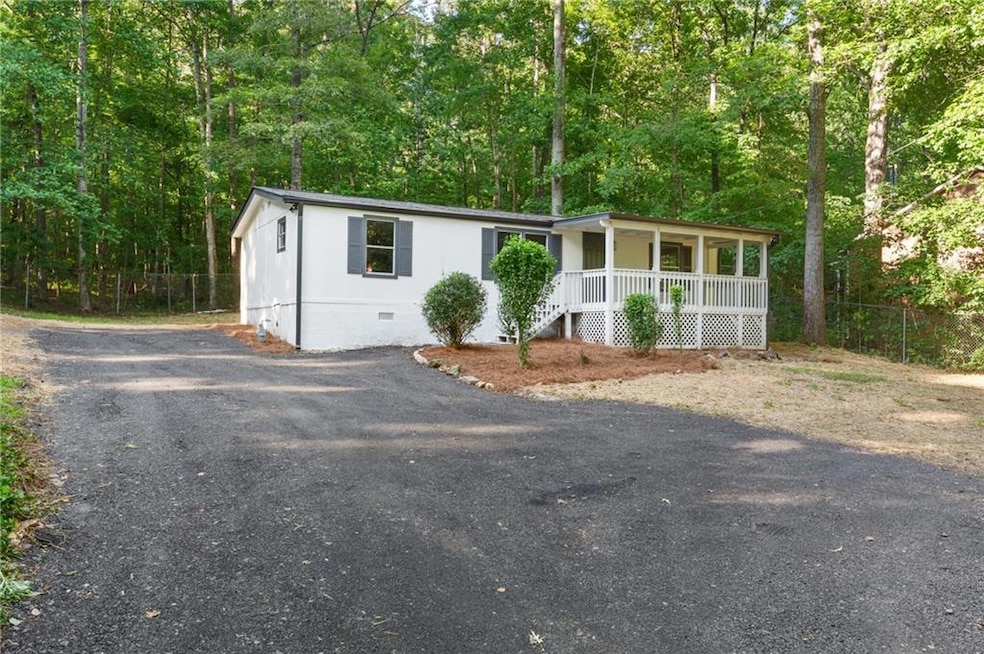 Manufactured / mobile home with a porch, crawl space, and a forest view
