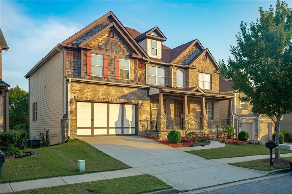 Craftsman inspired home with covered porch, driveway, a front yard, and a garage