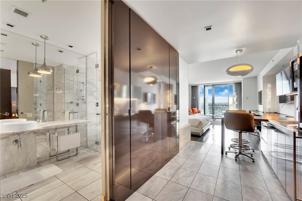 Bathroom with a shower stall, visible vents, a wal