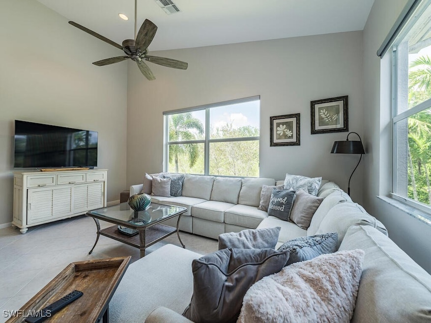 Tiled living room featuring vaulted ceiling, a hea