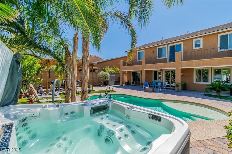 View of swimming pool with a patio, a hot tub, a balcony, and a fenced backyard