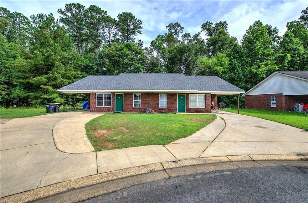 Ranch-style home featuring driveway, a carport, and a front lawn