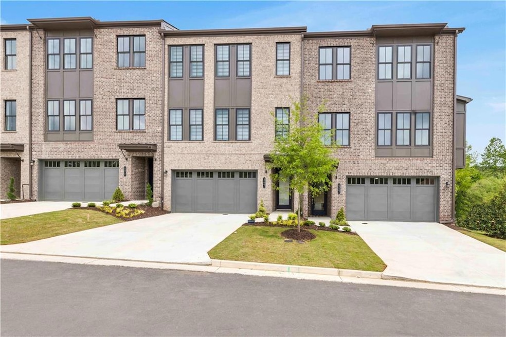 View of front of home featuring a garage, brick si