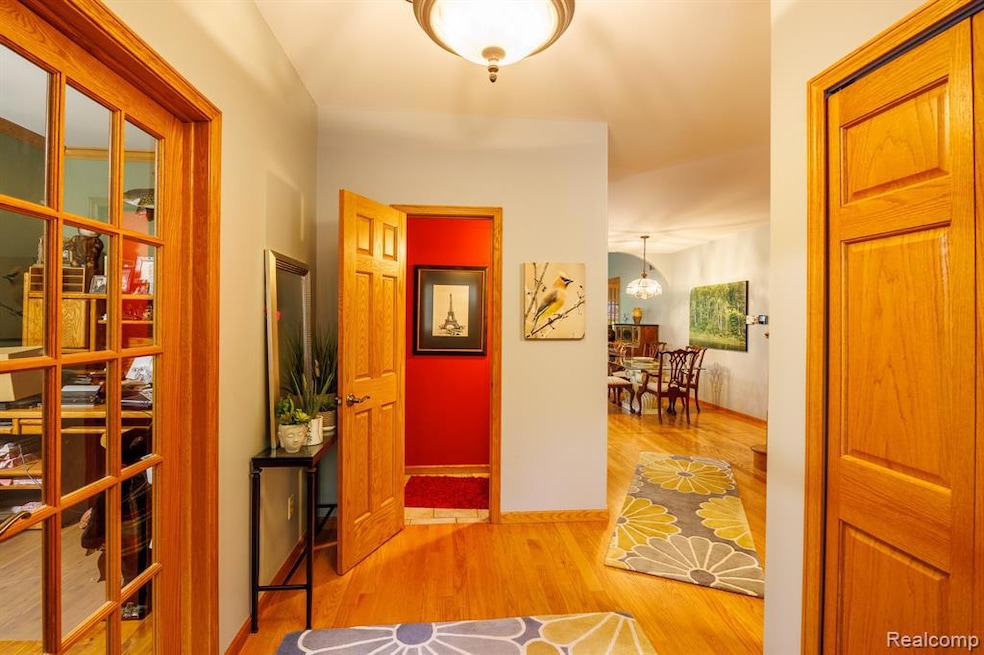 French country style house with stone siding, driveway, an attached garage, and roof with shingles