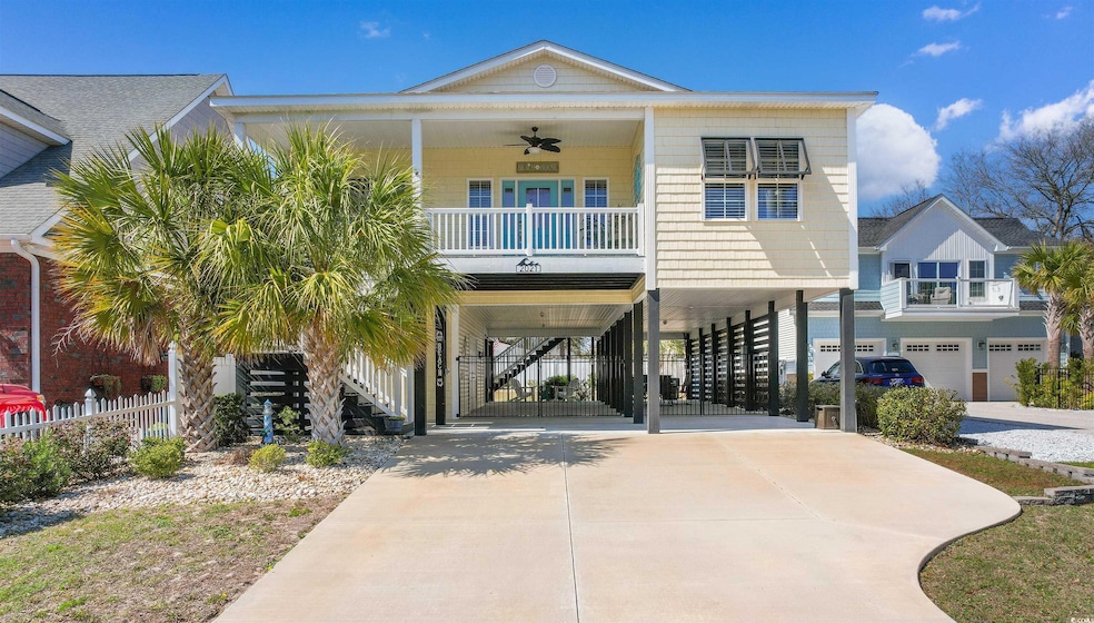 Beach home with stairs, ceiling fan, driveway, a p