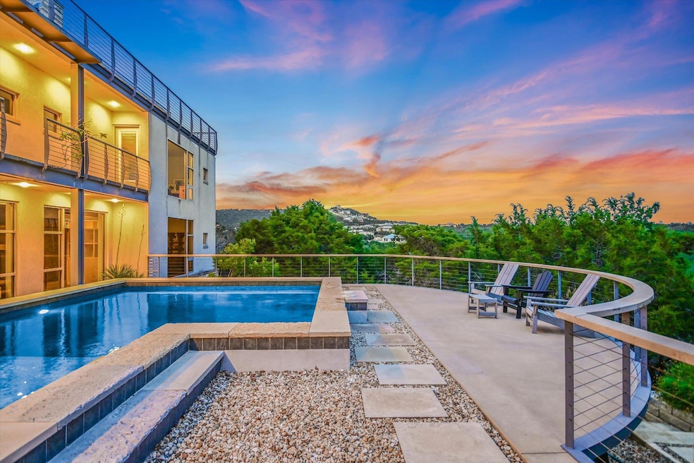 Pool at dusk with a hot tub and a patio