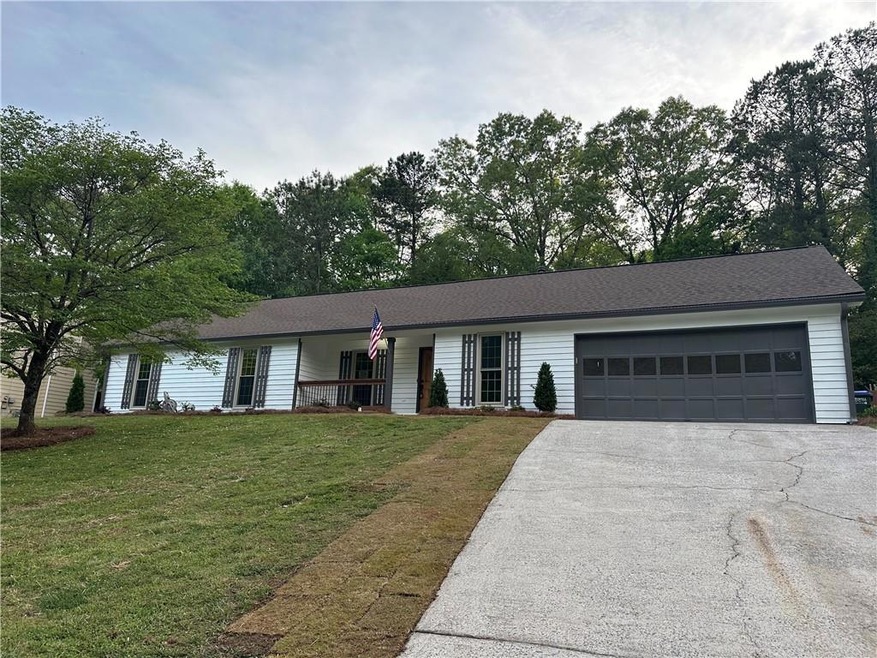 Single story home with a garage and a front yard