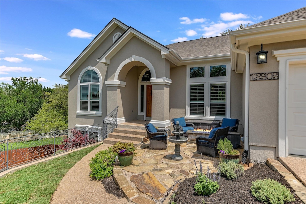 Property entrance with roof with shingles, stucco siding, and a patio