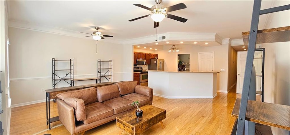 Living room featuring crown molding, a ceiling fan, light wood-style flooring, baseboards, and recessed lighting