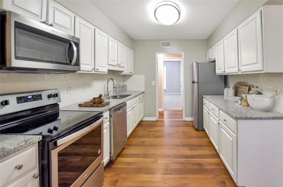 Kitchen featuring white cabinetry, light hardwood 