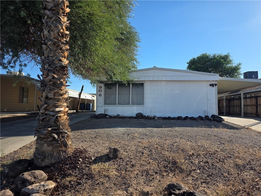 View of front facade featuring a carport, concrete driveway, and a sunroom