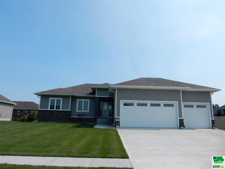 Front view of house and driveway showing three car