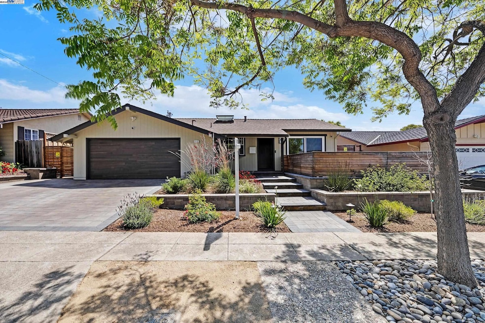Landscaping makeover with stone pavers at drive, walkways and raised courtyard deck