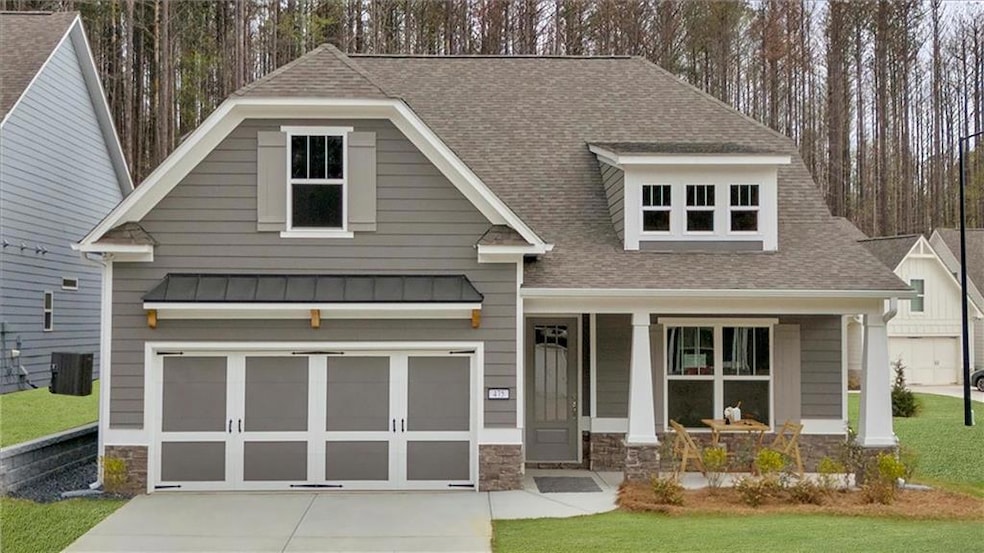 Craftsman inspired home with roof with shingles, an attached garage, stone siding, and concrete driveway