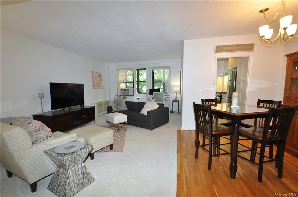 The entrance foyer overlooks the spacious living room and adjacent dining area, and a door at the rear leads to the inviting window-enclosed balcony - perfect for entertaining inside or out!