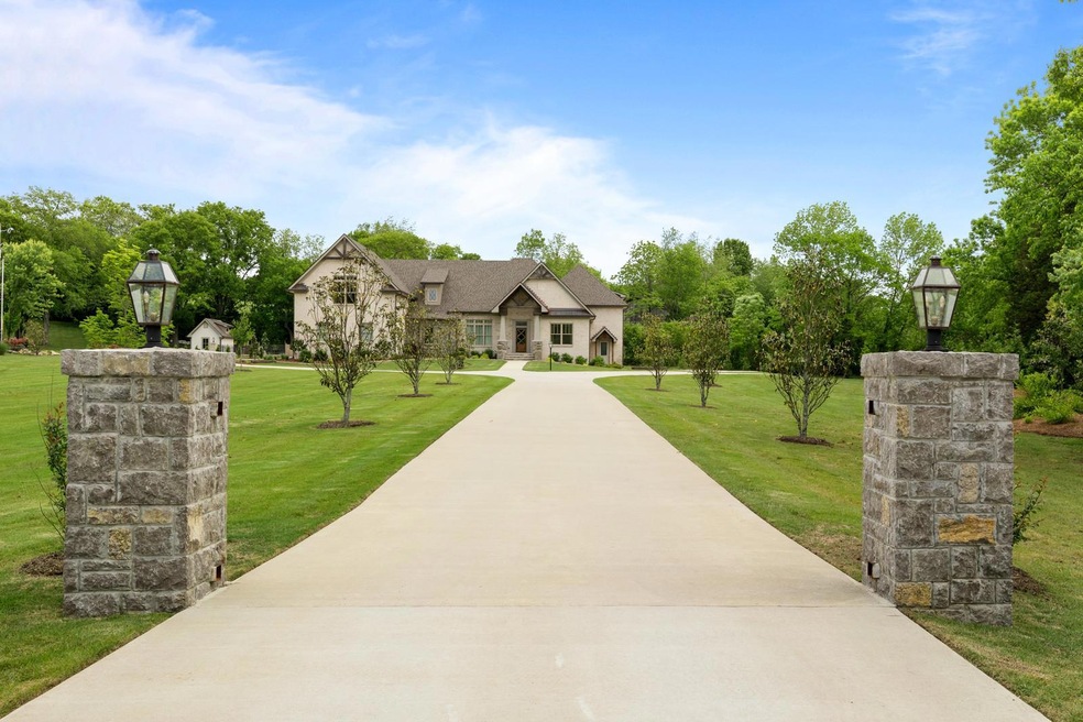 The stone pillars adorned with custom lighting add the perfect entrance to this gorgeous estate!