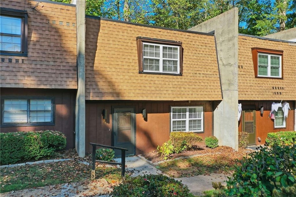 View of front of home with mansard roof and a shingled roof