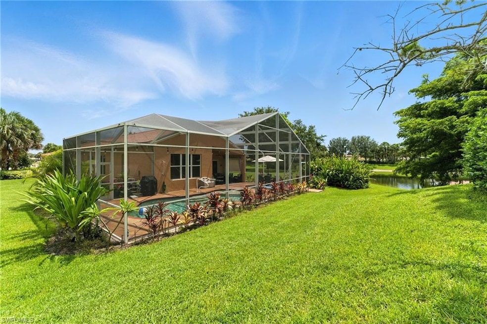 Rear view of house with a lawn, a patio area, a water view, an outdoor pool, and glass enclosure