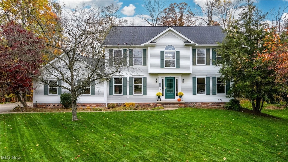 View of front facade featuring a front yard, a shingled roof, and crawl space