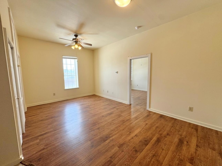 Spare room with ceiling fan, wood finished floors