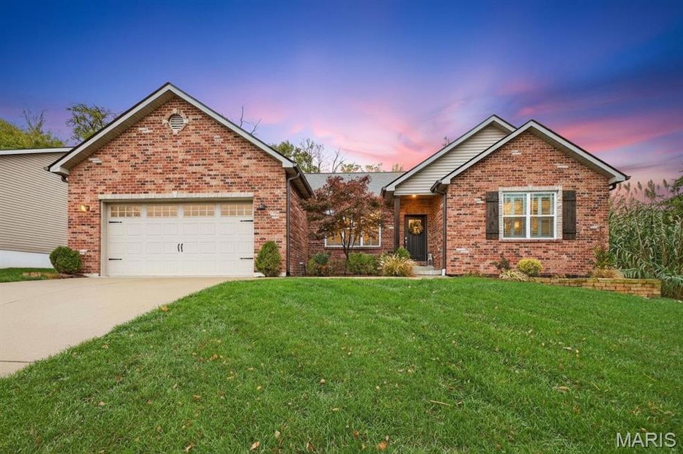 Ranch-style house featuring a lawn, driveway, brick siding, and a garage