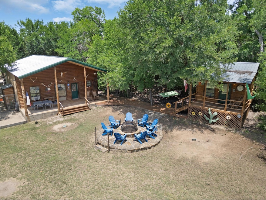 View of green lawn featuring a fire pit and a woo
