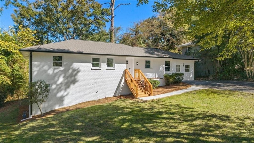 Back of house featuring a yard and brick siding
