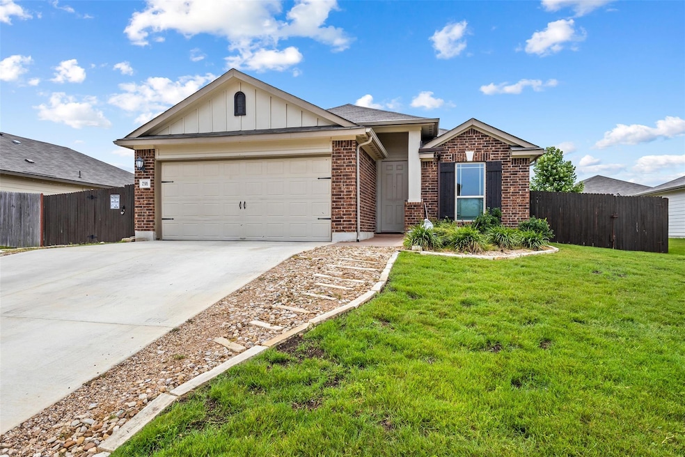 Single story home with driveway, brick siding, a 