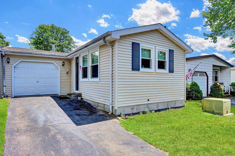 View of front of house featuring an attached garage, asphalt driveway, and a front yard