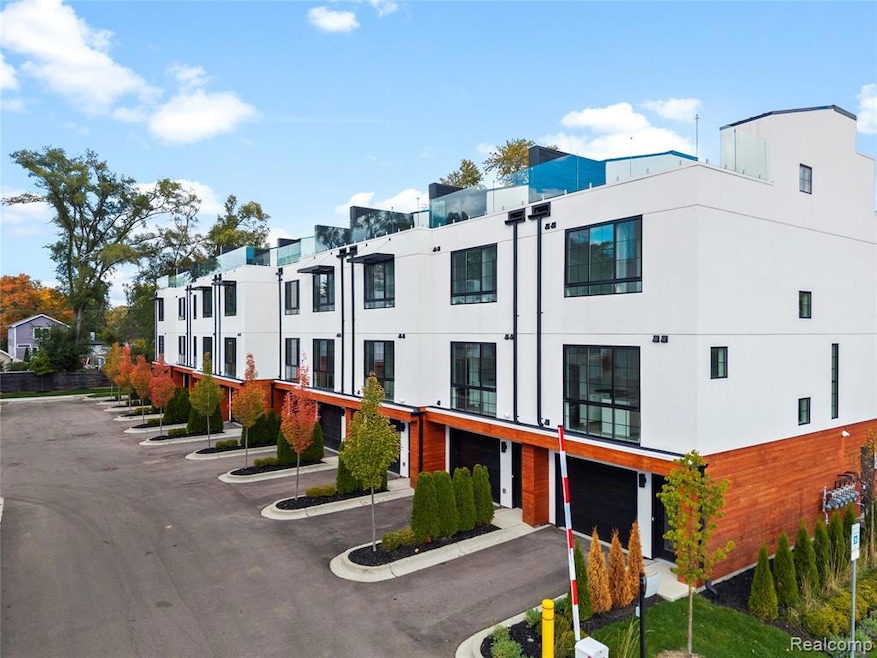 View of building exterior featuring an attached garage, driveway, and a residential view