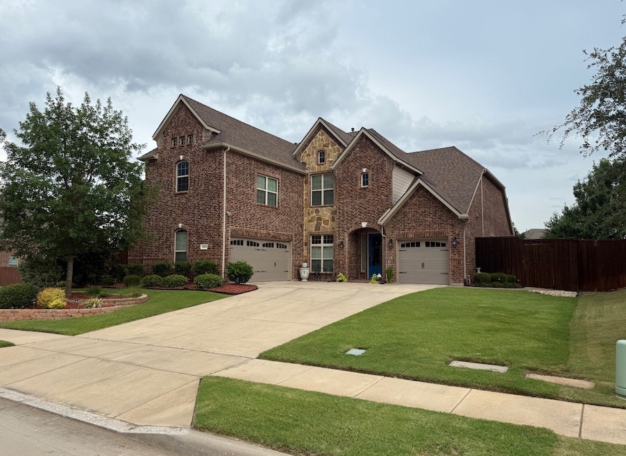 View of front of home featuring brick siding, concrete driveway, and a garage