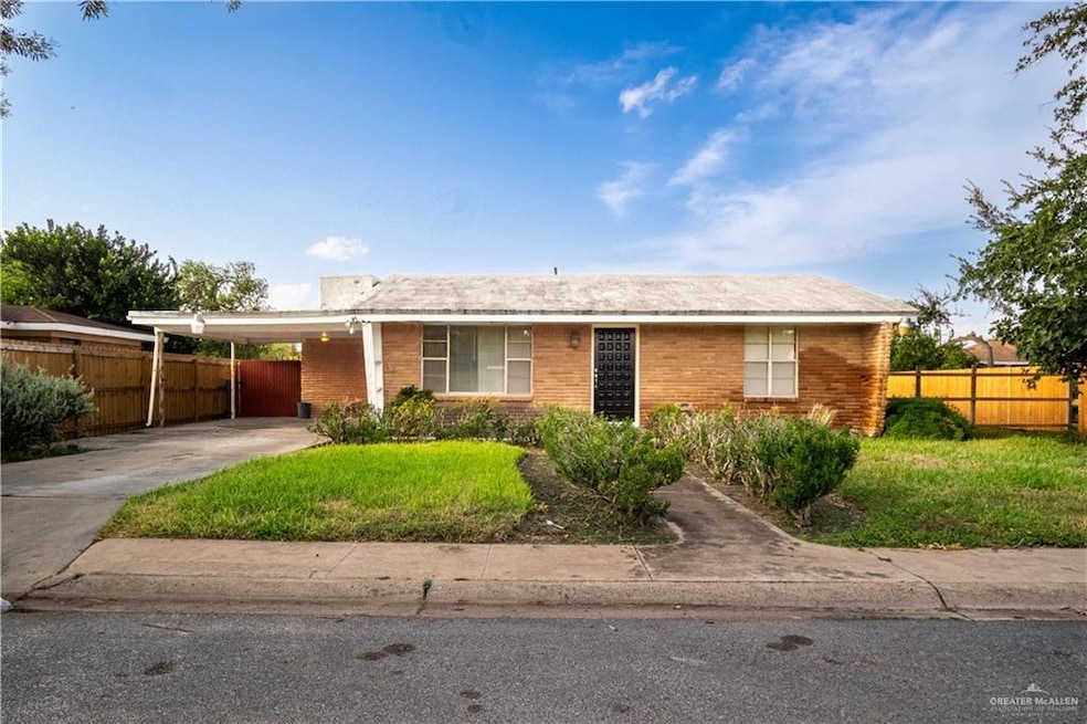 Ranch-style home with driveway, brick siding, and a carport