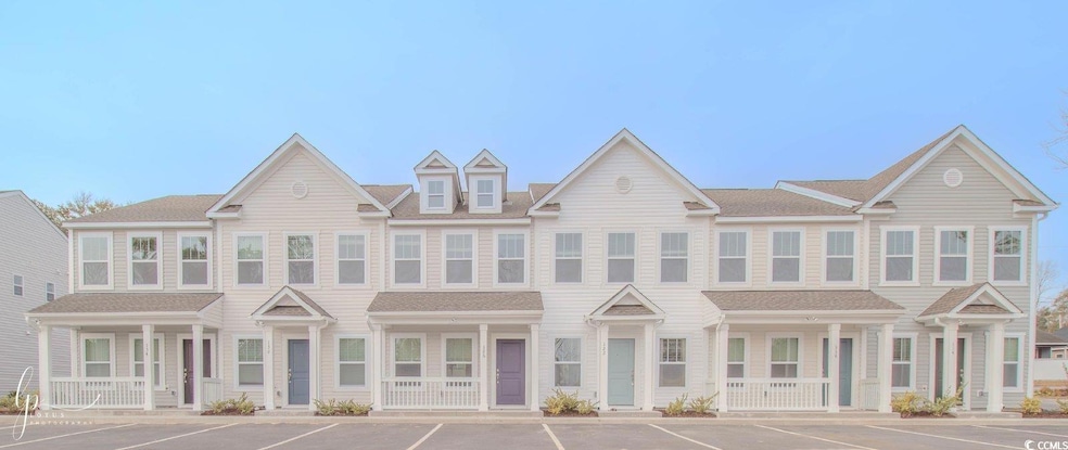 Townhome / multi-family property featuring covered porch and uncovered parking