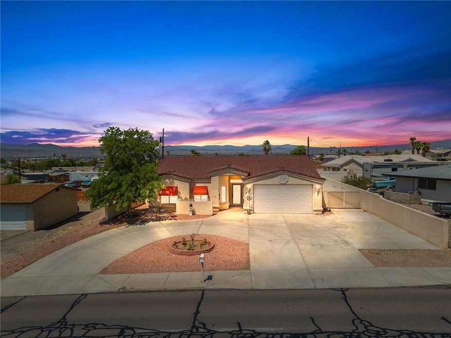 View of front facade featuring curved driveway, a garage, a mountain view, stucco siding, and a tiled roof